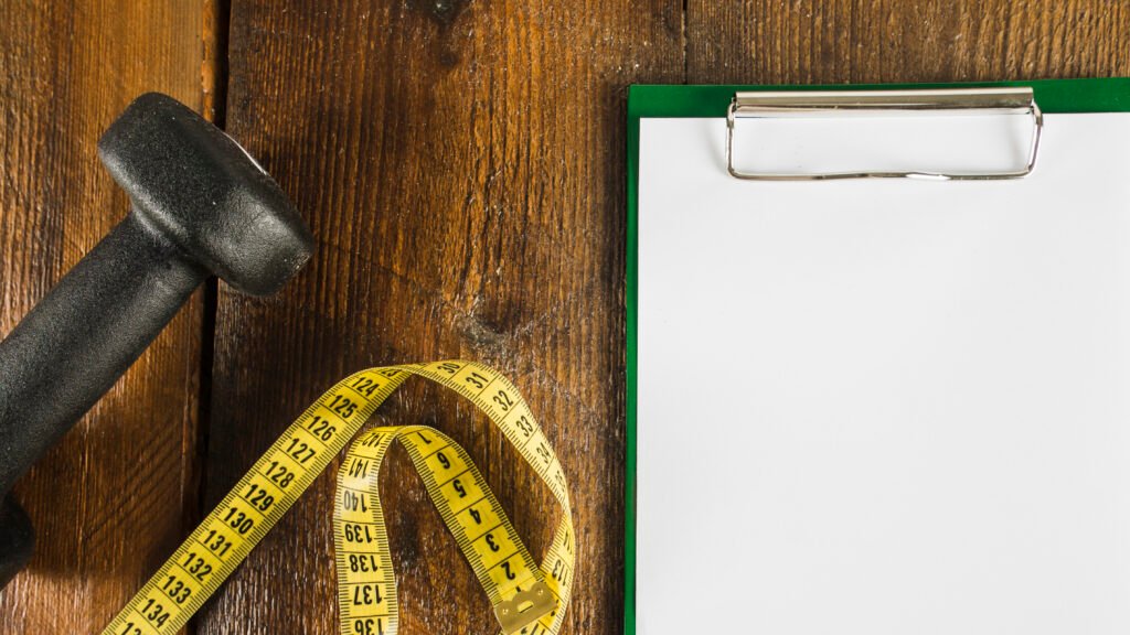 fita métrica e caderno de anotação